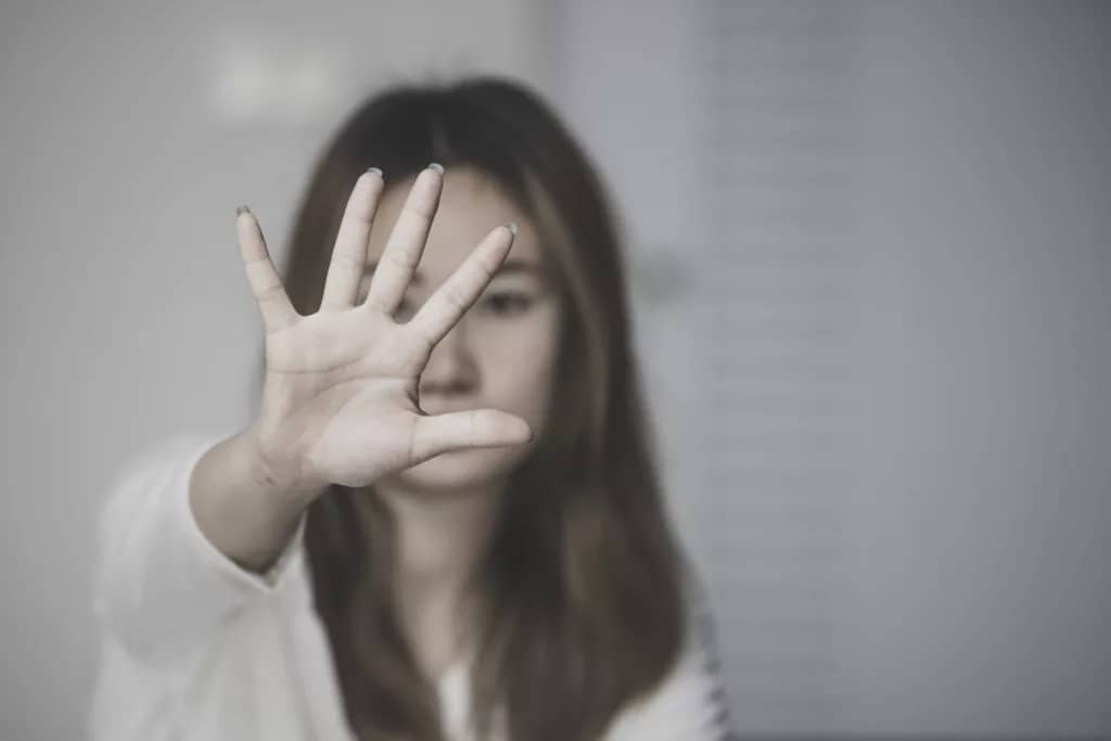 Stop violence against women, Woman covering her face in fear of domestic violence, Dark tone
